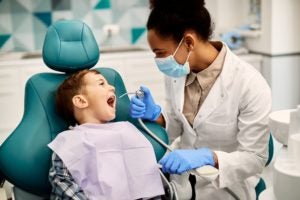dental hygienist examining teeth of a small boy at dental clinic