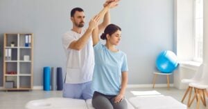male physiotherapy helping a client through stretching